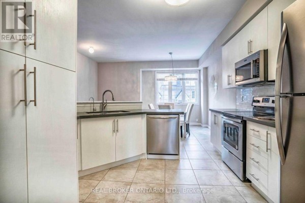 Kitchen with white cabinetry, stainless steel appliances, and a tiled floor. - 1424 Granrock Crescent, Mississauga