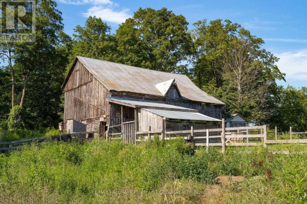 Rustic wooden barn with a corrugated metal roof and a smaller attached shed. - 1424 Klondike Park Road, Clearview