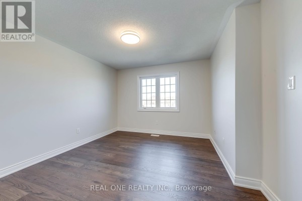 Bedroom with dark hardwood floors and window - 1426 Redwing Court Oakville