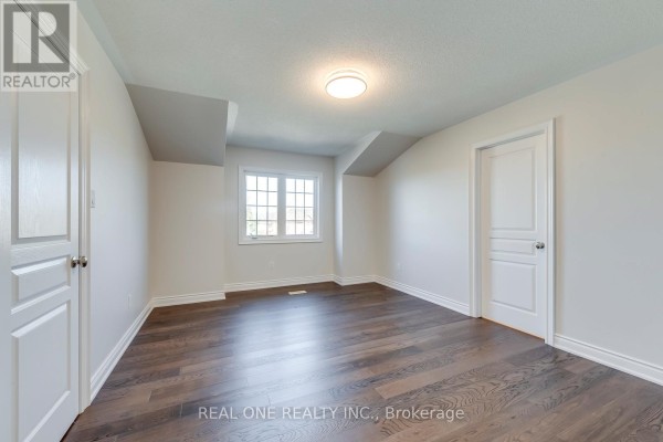 Bedroom with dark hardwood floors and a window - 1426 Redwing Court Oakville