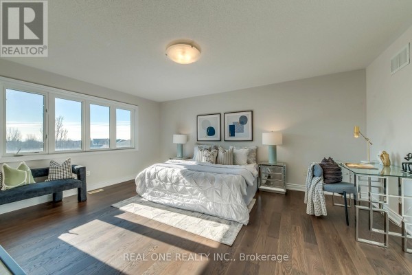 Bedroom with king bed, desk, bench seating, and large windows - 1426 Redwing Court Oakville