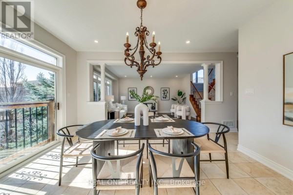 Dining room with oval table, chairs, ornate chandelier, and view to living room - 1426 Redwing Court Oakville
