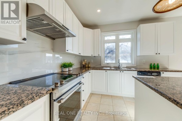 Renovated kitchen with white cabinets, granite counters, and stainless steel appliances - 1426 Redwing Court Oakville