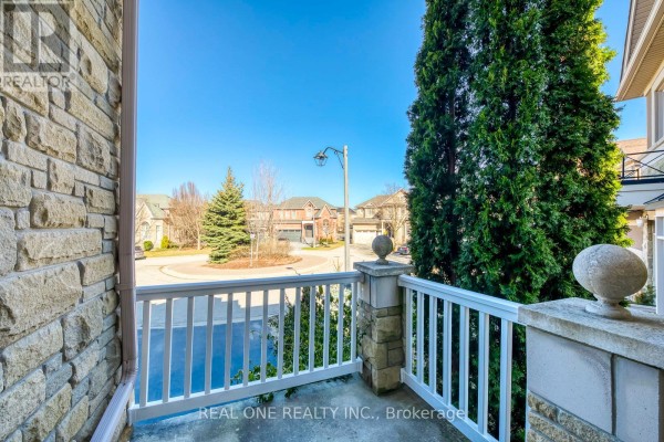 Balcony view of houses on a street with trees and a circular driveway - 1426 Redwing Court Oakville