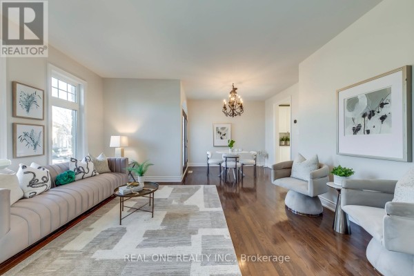 A living room with a white sofa, two armchairs, and a fireplace. - 1426 Redwing Court, Oakville