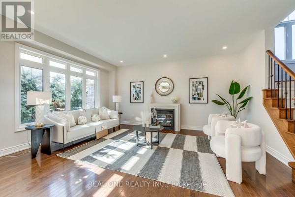 Modern living room with fireplace, sofa, chairs, and large windows - 1426 Redwing Court Oakville