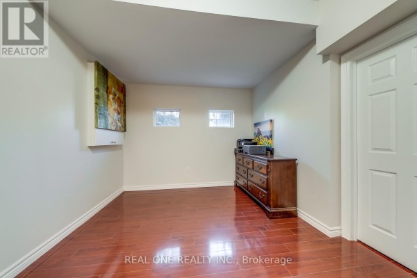 Bedroom with hardwood floors, chest of drawers, and two windows - 1426 Redwing Court Oakville