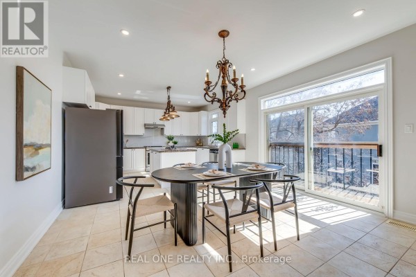 Dining area with oval table, chairs, and modern chandelier open to kitchen - 1426 Redwing Court Oakville