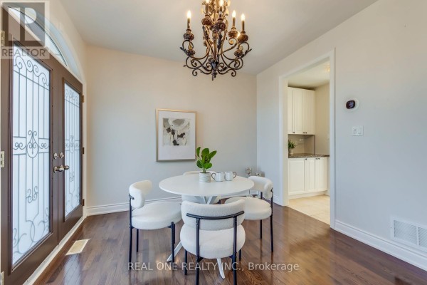 Dining room with round table, modern chairs, and ornate chandelier - 1426 Redwing Court Oakville