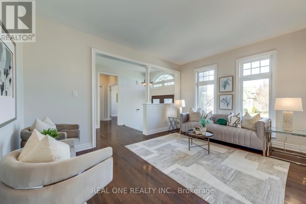 Living room with tufted sofa, coffee table, and large windows - 1426 Redwing Court Oakville