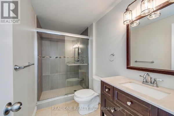Glass-enclosed shower, vanity, and mirror in a renovated bathroom - 1426 Redwing Court Oakville
