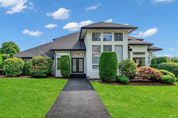 Front view of the house with green shrubs and clear blue sky - 14260 82a Avenue, Surrey