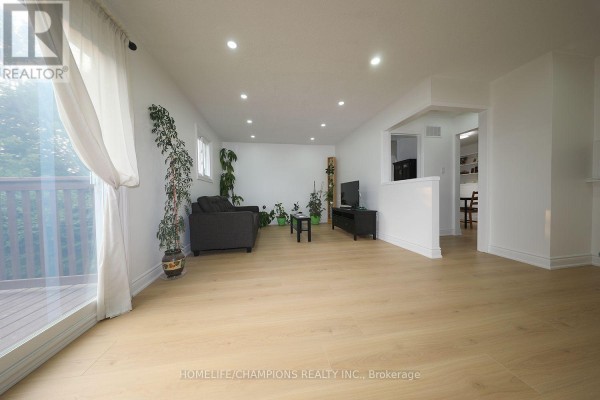 View of the living room with light wood floors and a white partition wall. - 1428 Outlet Drive, Oshawa