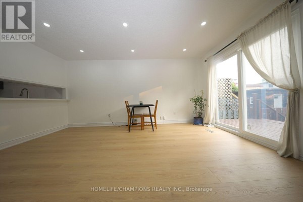 Dining area with a black table and chairs, next to a hallway leading to a bedroom. - 1428 Outlet Drive, Oshawa