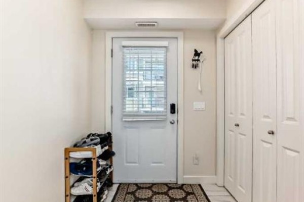 Entrance to unit 143 with a welcome mat and stone detailing on the porch. - 143, 300 Marina Drive, Chestermere