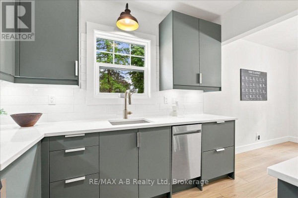 Modern kitchen with gray cabinets, quartz countertops, and subway tile backsplash - 143 Britannia Street Stratford