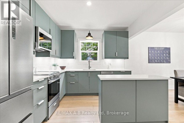 Modern kitchen with grey cabinets, stainless steel appliances, and quartz countertops - 143 Britannia Street Stratford