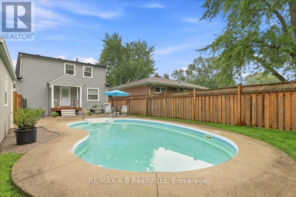 Freeform swimming pool with patio and wooden fence - 143 Britannia Street Stratford