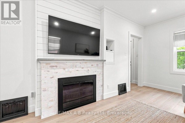 Fireplace with mounted TV and wood floors - 143 Britannia Street Stratford