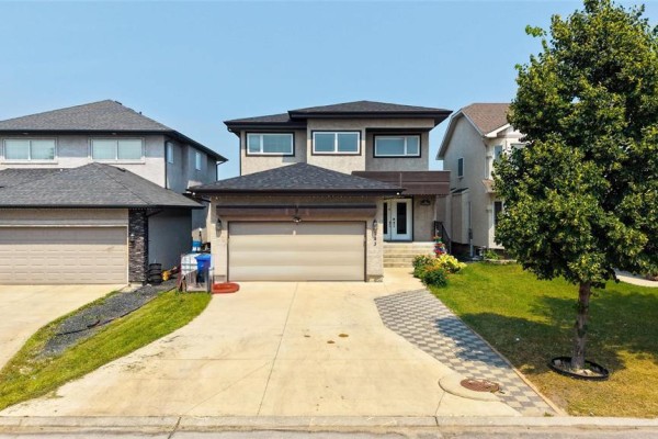 Front exterior of a modern house with a beige stucco finish and an attached garage. - 143 Mosselle Drive, Winnipeg
