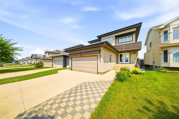 Exterior view of a modern house on a suburban street with a paved driveway. - 143 Mosselle Drive, Winnipeg
