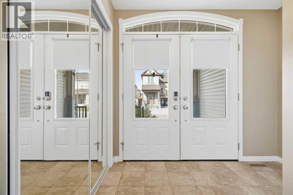 Interior view of double doors with glass panels and reflective mirrored closet doors. - 143 Windbrook Manor Sw, Airdrie