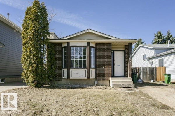Front exterior of a brick bungalow with a bay window and a covered porch. - 14304 32 St Nw, Edmonton