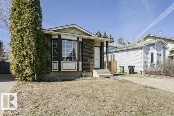 Front right view of a brick bungalow with a paved driveway and garbage bins. - 14304 32 St Nw, Edmonton