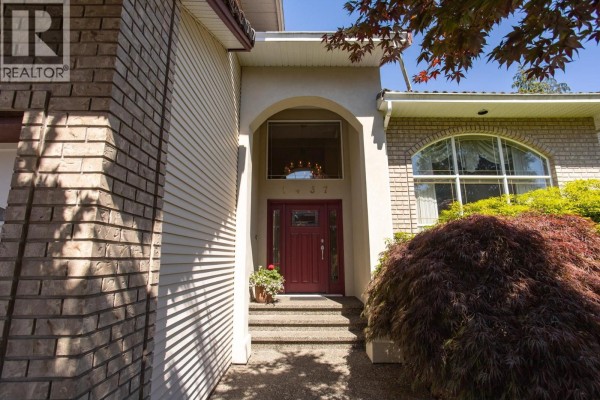 Front entrance walkway with a red door, brick and stucco facade, and arched window. - 1437 Lambert Way, Coquitlam