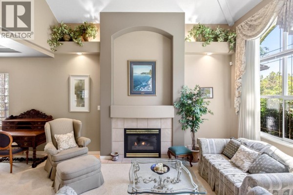 Living room fireplace with tiled surround, flanked by sofas and a vintage desk. - 1437 Lambert Way, Coquitlam