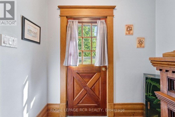 Wooden Dutch door with a multi-paned window and light grey walls. - 1438 Concession 3 Road, Adjala Tosorontio
