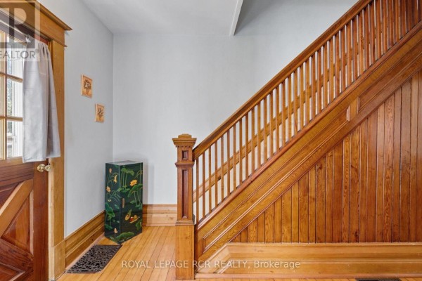 Wooden staircase with a turned newel post, fluted balusters, and paneled wainscoting. - 1438 Concession 3 Road, Adjala Tosorontio