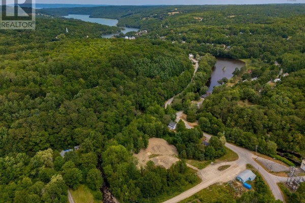 Aerial view of a rural landscape with dense trees, a winding river, and scattered houses. - 1438 River Road, Bear River