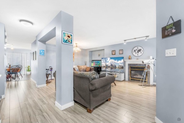 Living room with gray walls, hardwood flooring, and a fireplace. - 144 3080 Townline Road Road, Abbotsford