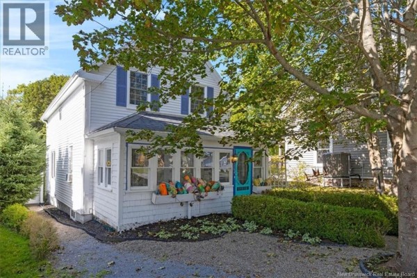 Exterior view of a white two-story house with a gravel driveway and manicured hedges. - 144 Frederick Street, Saint Andrews