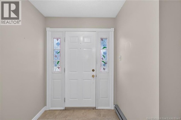 White front door with decorative stained glass side panels and beige walls. - 144 Harvey Road, Riverview