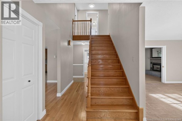 Interior foyer with staircase, hardwood floors, white doors, and light grey walls. - 144 Harvey Road, Riverview