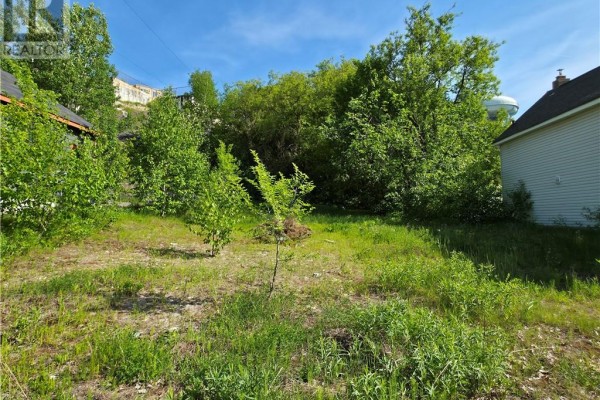 Snow-covered lot with hillside in the background and nearby houses. - 144 Mountain Street, Sudbury