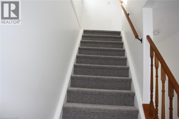 Entrance to kitchen area with white cabinetry and laminate flooring - 144 Sekura Crescent, Cambridge