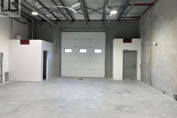 Open warehouse space with concrete floor and utility connections. - 1441 Clark Avenue Unit# 104, Penticton
