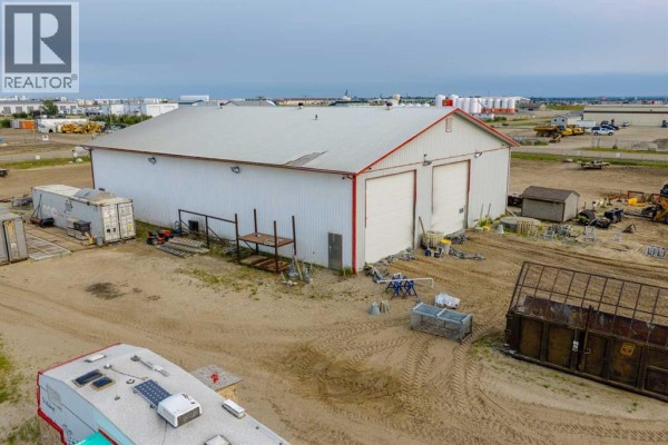 Side view of a white commercial building with red trim and two large bay doors. - 14410 102 Street, Rural Grande Prairie No  1, County Of