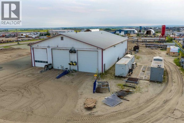 View of the front of a commercial building with two bay doors and surrounding industrial yard. - 14410 102 Street, Rural Grande Prairie No  1, County Of