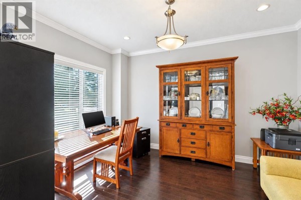 Entrance foyer with tile flooring, dark wood door, and carpeted stairs. - 1443 40 Street Sw, Calgary