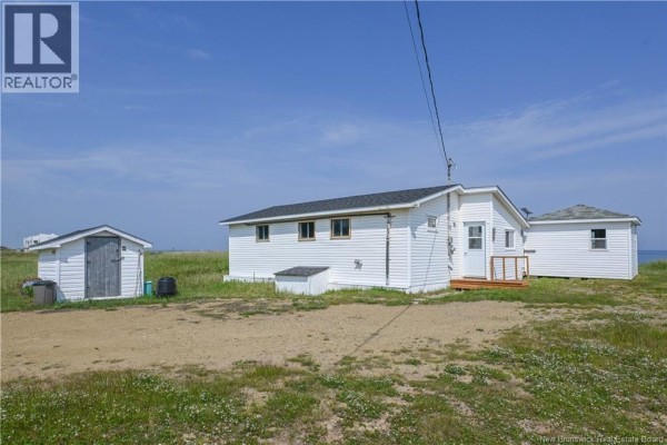 View of dining area, hallway, and kitchen with white cabinets and wooden walls. - 145 Des Chalets Road, Maisonnette