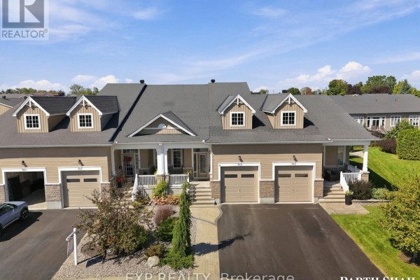 Aerial view of a beige townhouse complex with green lawns and manicured landscaping. - 145 Oxford Street W, North Grenville
