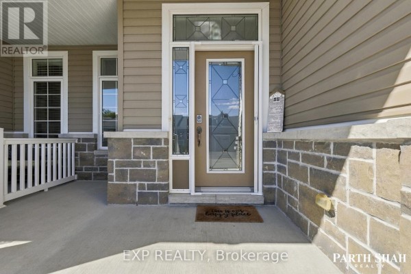 Close-up of the townhouse front entrance with a glass-paned door and stone facade. - 145 Oxford Street W, North Grenville