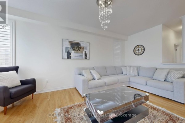 Living room with a large sectional sofa, a coffee table, a dark accent chair, and a chandelier. - 145 Silver Maple Road, Richmond Hill