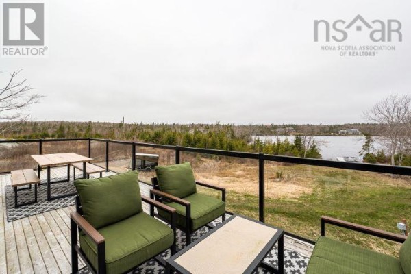 Living room with a grey sectional sofa and dining room with dark wood table. - 145 Yellowleaf Lane, Portuguese Cove