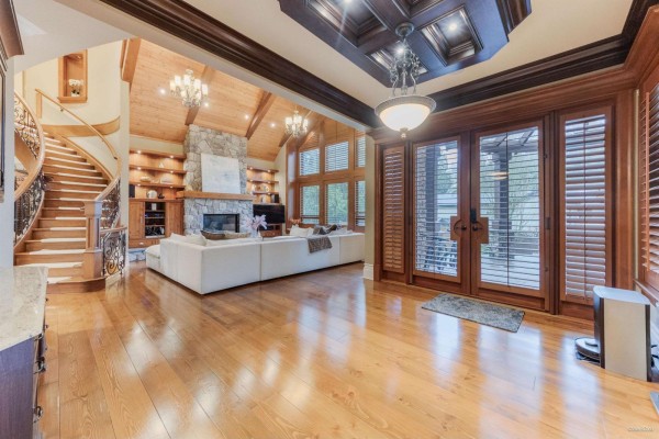 Living room with large sectional sofa, stone fireplace, wood ceiling, and window wall. - 14526 32b Avenue, Surrey