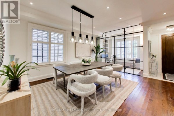Modern kitchen with white cabinetry, dark blue island, stainless steel appliances, and hardwood floors. - 145b Bannockburn Avenue, Toronto